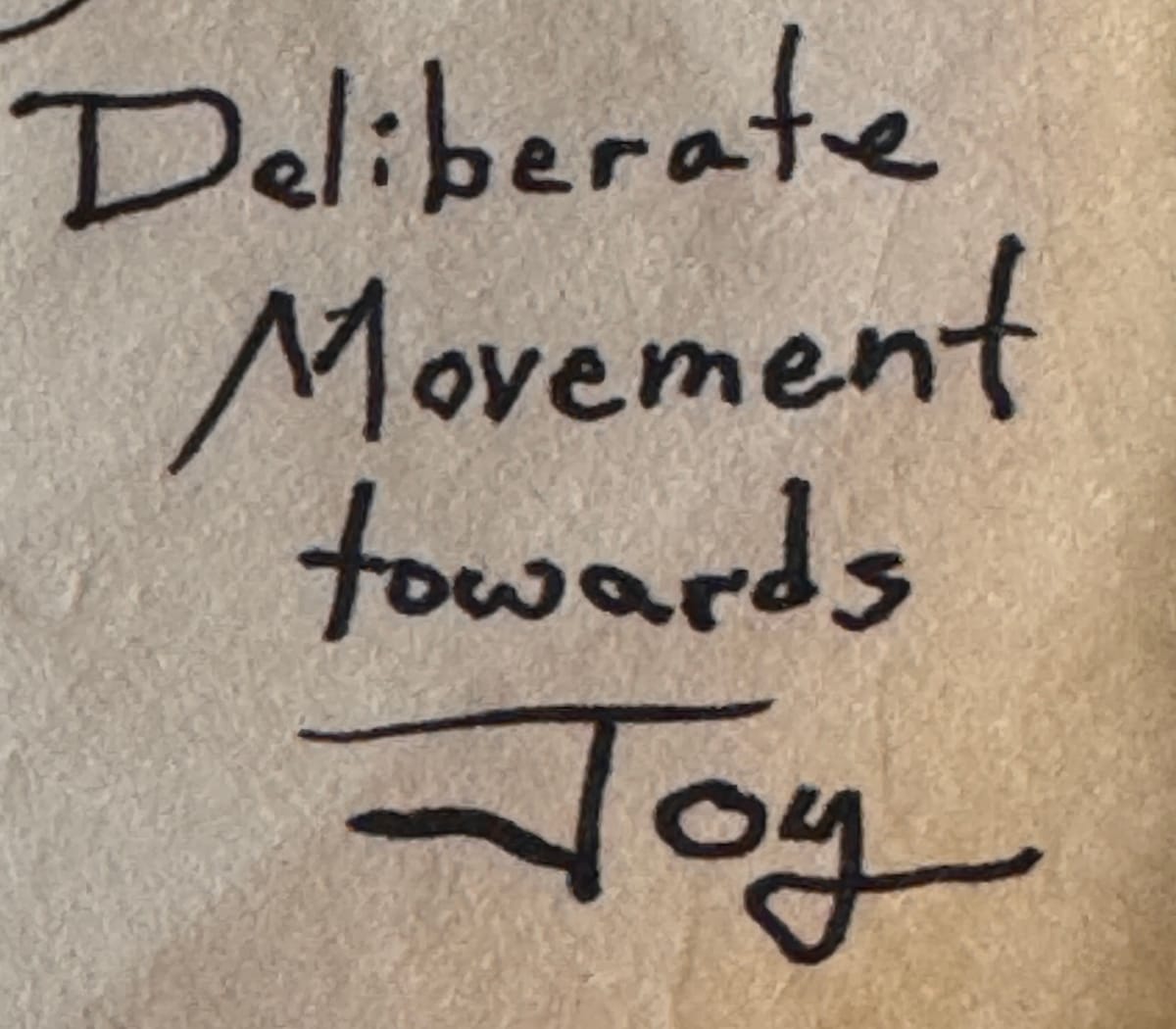 Handwriting that shows the words “Deliberate Movement towards Joy.”
